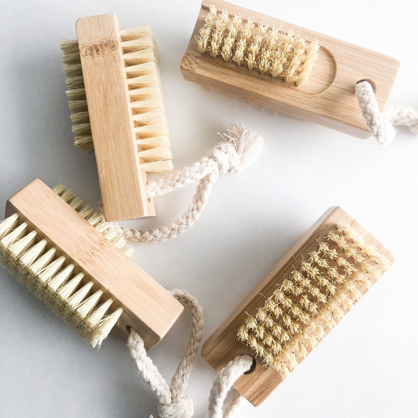Close-up of natural bamboo nail brush showing textured bristles and rope loop