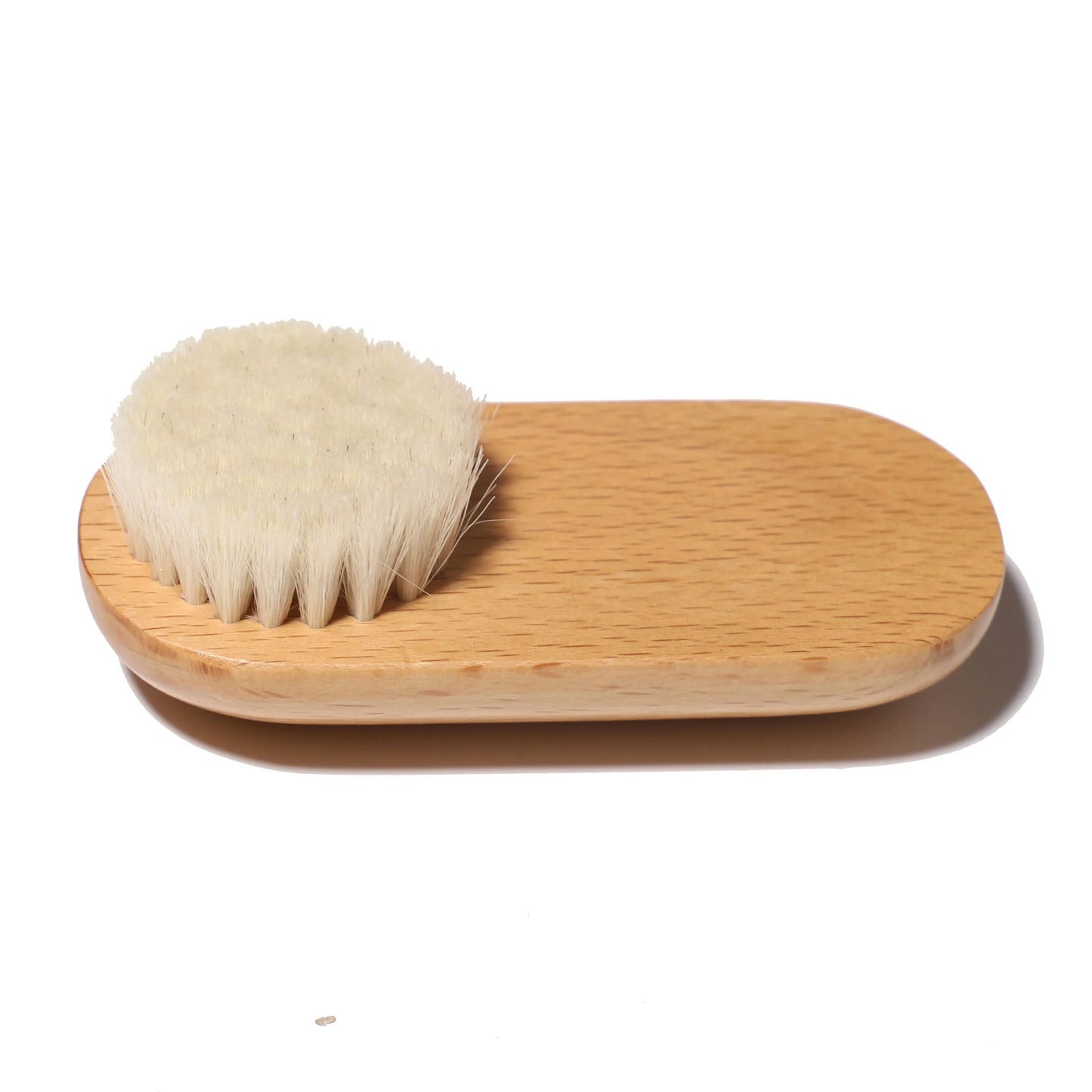 Natural dry face brush with curved wooden handle, shown on white background