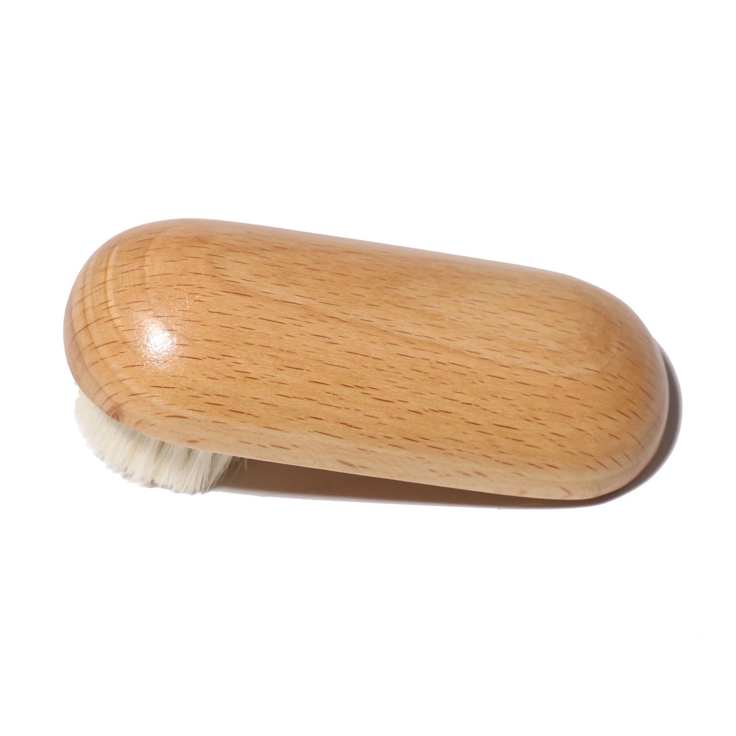 Sustainable wooden face brush photographed flat against white surface