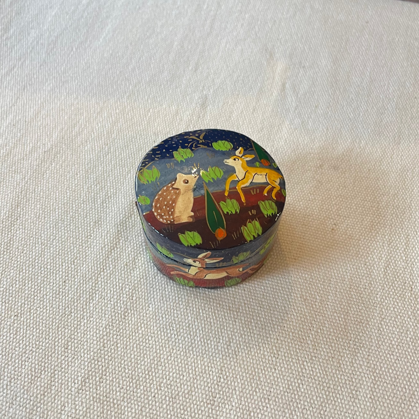 Glossy papier mâché trinket box featuring hedgehogs, hares and deer in starry forest
