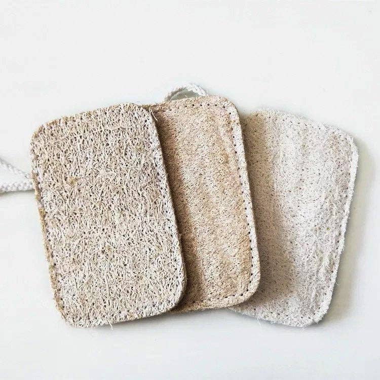 Group of three natural loofah sponges on natural background, slightly overlapping