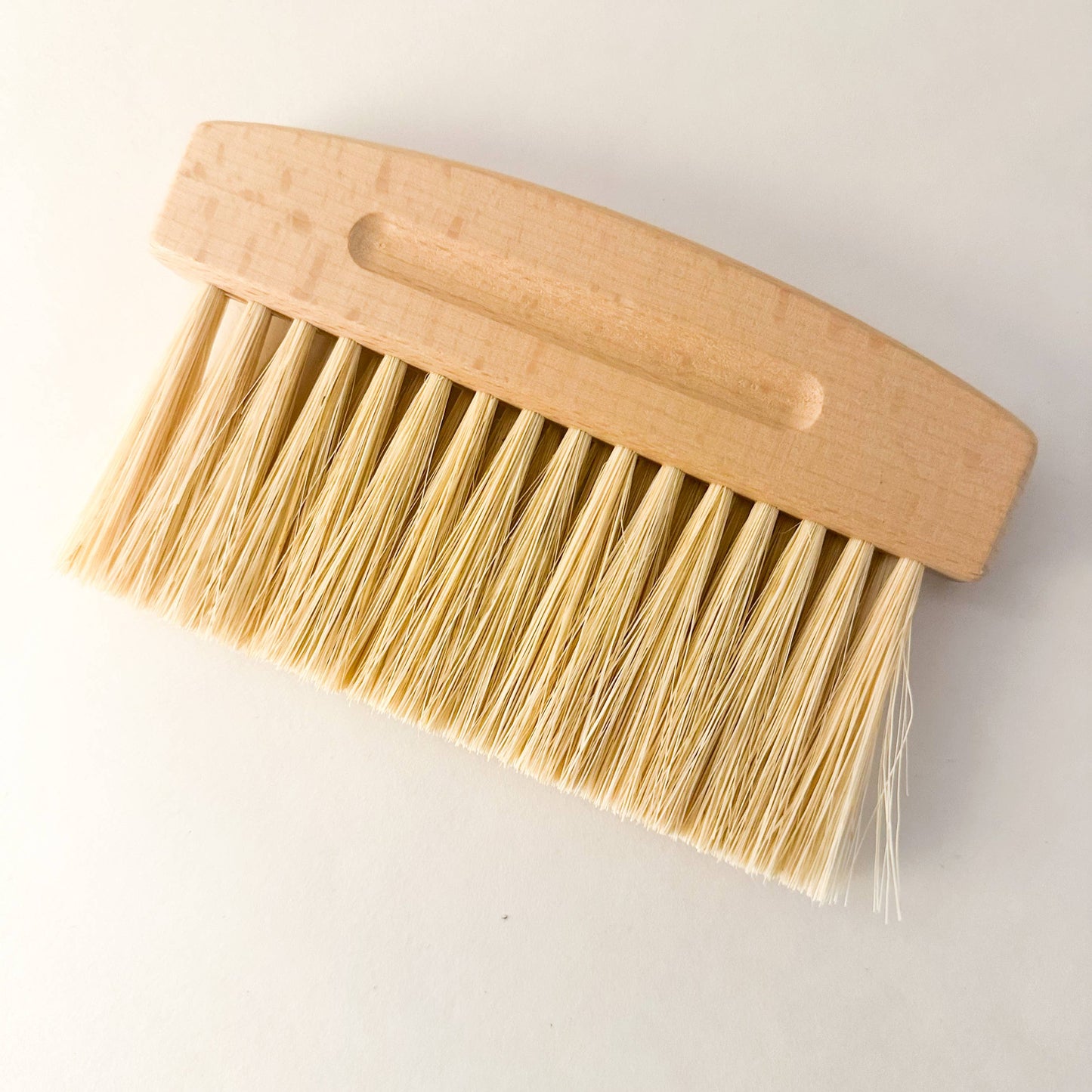 mini dustpan and brush set, brush on against neutral background