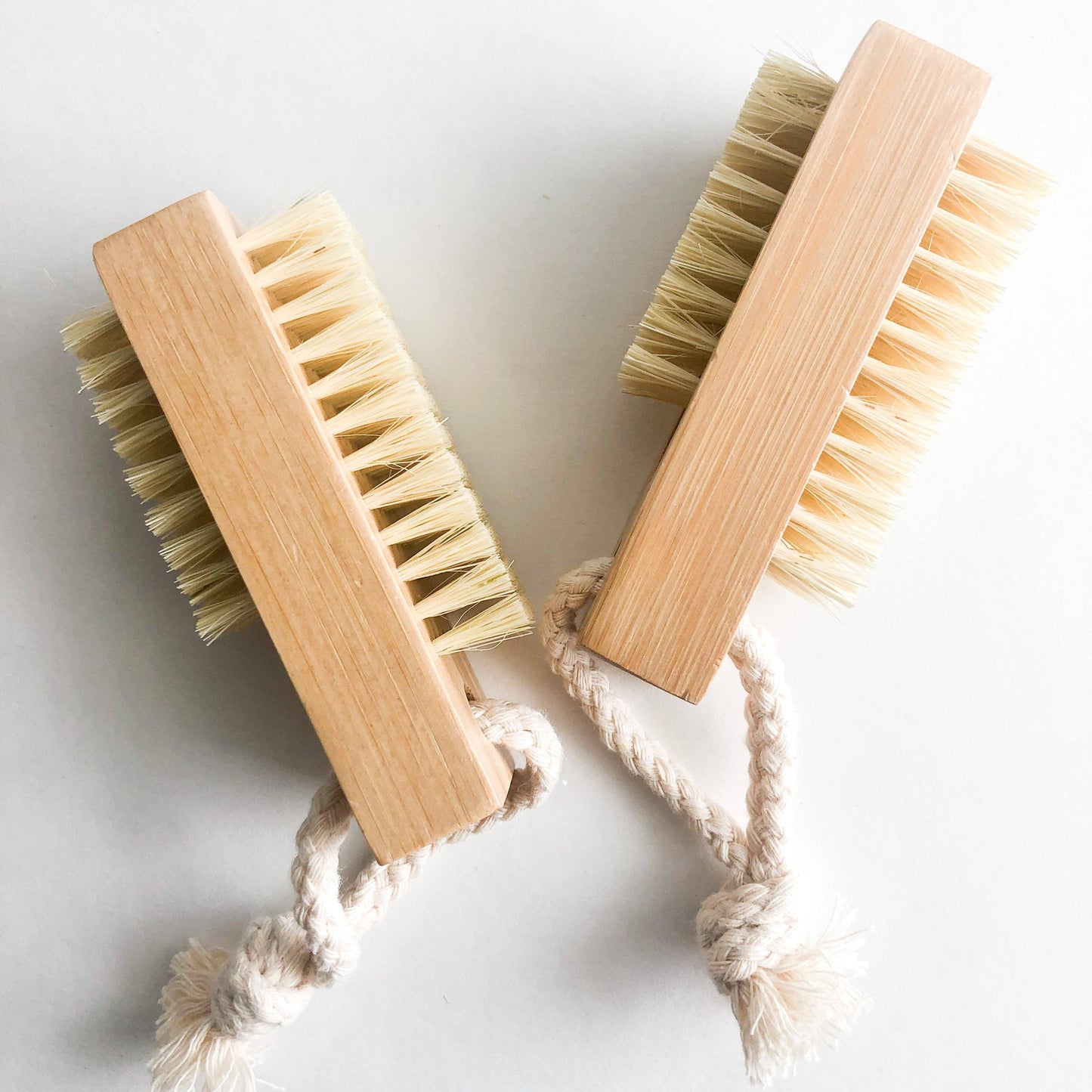 Close-up of natural bamboo nail brush showing textured bristles and rope loop