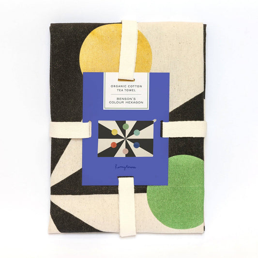 Colour wheel design organic cotton tea towel folded and tied with a fabric ribbon, presented in minimalist packaging against a white background.